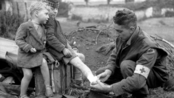 Un adolescent soigne le pied d'un enfant